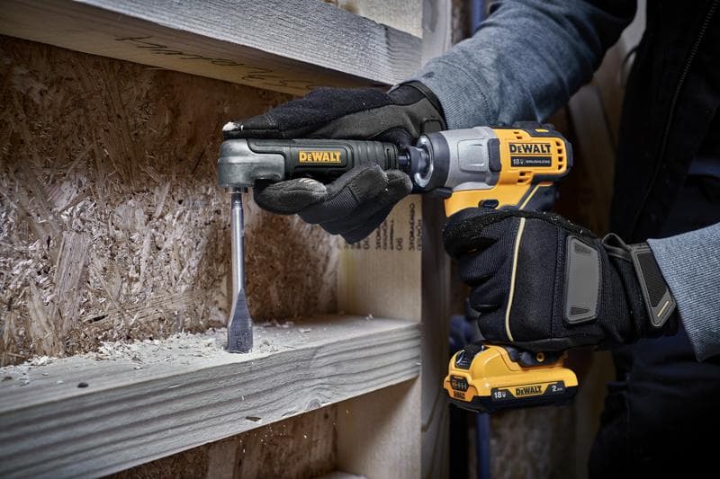Uma pessoa usando luvas de trabalho utiliza uma furadeira sem fio DEWALT com um acessório para perfurar uma viga de madeira.