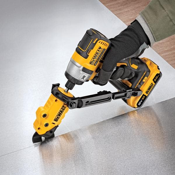 Uma pessoa usando luva está utilizando uma ferramenta elétrica amarela e preta DEWALT DT70620 para cortar uma chapa de metal. A ferramenta é operada por bateria e possui um acessório de corte para trabalhos de precisão.